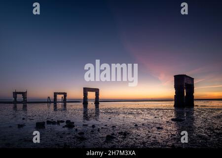 Ruine de l'ancien quai de ferry à Eckwarderhörne à marée basse dans la lumière du soir, Butjadingen, Wesermarsch, Basse-Saxe, Allemagne,Europe Banque D'Images