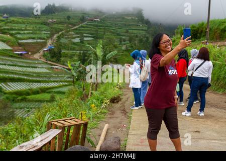 Une femme asiatique prenant un selfie dans la campagne avec un fond de légumes plantés sur la terrasse d'une montagne.MAGELANG CENTRAL JAVA, INDONES Banque D'Images