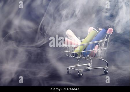 Vapes jetables dans un panier sur fond noir.Cigarettes électroniques modernes. Banque D'Images