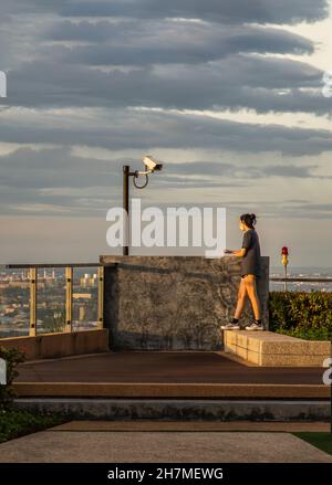 Bangkok, Thaïlande - 31 juillet 2021 : une jeune femme non identifiée se détendant sur le toit-terrasse avec vue sur la ville.Espace de copie, mise au point sélective. Banque D'Images