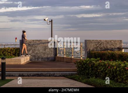 Bangkok, Thaïlande - 31 juillet 2021 : une jeune femme non identifiée se détendant sur le toit-terrasse avec vue sur la ville.Espace de copie, mise au point sélective. Banque D'Images