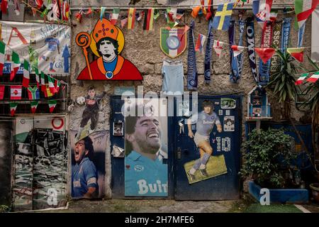 Neapel, Italie.23 novembre 2021.Des photos et des images de la légende Argentine du football Maradona sont accrochées à côté des drapeaux sur un mur dans le quartier espagnol.Un an après la mort de la star du football dans une résidence privée au nord de Buenos Aires, Maradona est commémoré avec des hommages, des séries télévisées et des mémoriaux - y compris à Naples, où le 'Golden boy' a joué pendant des années à SSC Napoli.(À dpa 'Un an sans Diego: Hommages et accusations à l'anniversaire de la mort de Maradona') Credit: Alessio Paduano/dpa/Alay Live News Banque D'Images