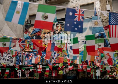 Neapel, Italie.23 novembre 2021.Des photos de la légende Argentine du football Maradona sont accrochées à côté des drapeaux dans les quartiers espagnols.Un an après la mort de la star du football dans une résidence privée au nord de Buenos Aires, Maradona est commémoré avec des hommages, des séries télévisées et des mémoriaux - y compris à Naples, où le 'Golden boy' a joué pendant des années à SSC Napoli.(À dpa 'Un an sans Diego: Hommages et accusations à l'anniversaire de la mort de Maradona') Credit: Alessio Paduano/dpa/Alay Live News Banque D'Images