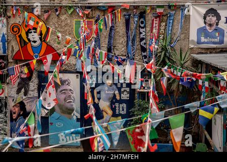 Neapel, Italie.23 novembre 2021.Des photos de la légende du football Maradona sont accrochées à côté des drapeaux dans les quartiers espagnols.Un an après la mort de la star du football dans une résidence privée au nord de Buenos Aires, Maradona est commémoré avec des hommages, des séries télévisées et des mémoriaux - y compris à Naples, où le 'Golden boy' a joué pendant des années à SSC Napoli.(À dpa 'Un an sans Diego: Hommages et accusations à l'anniversaire de la mort de Maradona') Credit: Alessio Paduano/dpa/Alay Live News Banque D'Images