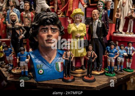 Neapel, Italie.23 novembre 2021.Des figurines de petite et grande taille de la légende du football Maradona sont en vente dans une boutique de souvenirs du quartier espagnol.Un an après la mort de la star du football dans une résidence privée au nord de Buenos Aires, Maradona est commémoré avec des hommages, des séries télévisées et des monuments - également à Naples, où le 'Golden boy' a joué pendant des années dans la SSC Naples.(À dpa 'Un an sans Diego: Hommages et accusations à l'anniversaire de la mort de Maradona') Credit: Alessio Paduano/dpa/Alay Live News Banque D'Images