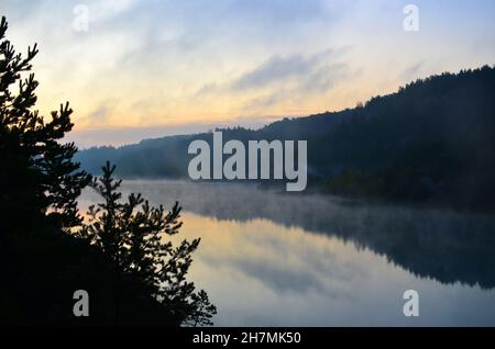 L'humeur le matin avec le lever du soleil avec une brume au-dessus d'un lac dans les montagnes. Ce lac artificiel formé après l'extraction de craie dans une carrière industrielle Banque D'Images
