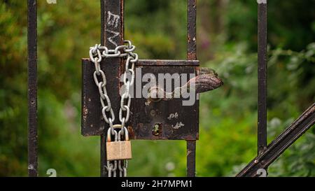 Le double tient mieux.Cadenas qui fixe une porte verrouillée.La propriété abîmée est sécurisée. Banque D'Images