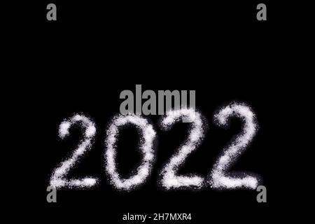 Bonne année 2022.Date 2022 écrit avec sel comme neige isolé sur fond noir.Objet de superposition créatif pour une carte postale. Banque D'Images