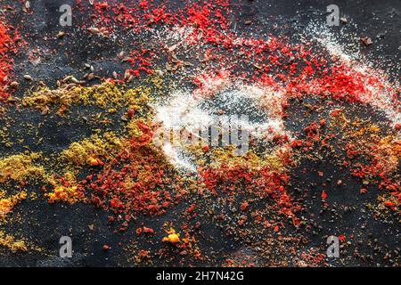 épices multicolores éparpillées pour la nourriture sur un fond noir de gros plan Banque D'Images