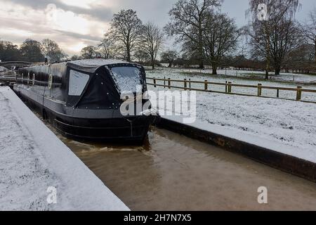 Un voilier noir entrant dans une écluse surgelée à Cheshire sur le canal de Shropshire Union au milieu de l'hiver Banque D'Images