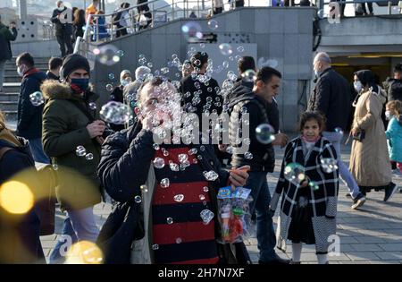 TURQUIE, Istanbul, gare maritime d'Eminönü, pandémie de corona, personnes avec masques faciaux, vendeur de bulles de savon / TÜRKEI, Istanbul, Stadtteil Eminönü Fähranleger, Corona Pandemie, Verkäufer mit Seifenblasen Spielzeug und Passanten mit Masken Banque D'Images