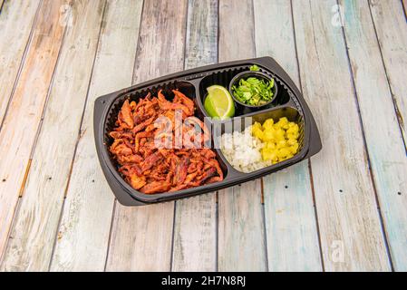 Plateau de livraison à domicile avec set de tacos al pasteur avec ragoût de viande, oignon, mangue, lime et coriandre Banque D'Images