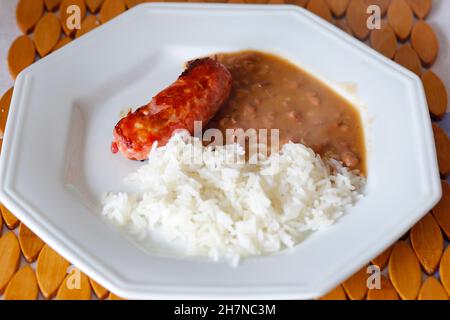 Riz, haricots et saucisses prêts à consommer sur une assiette blanche Banque D'Images