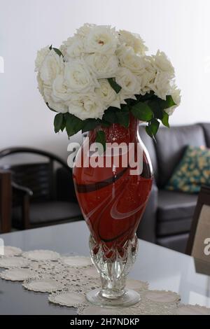 Grand vase rouge sur une table en verre à l'intérieur d'un appartement résidentiel.Salvador Bahia Brésil. Banque D'Images