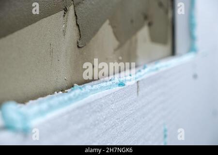 Installation de feuilles d'isolation en mousse de polystyrène sur le mur de la façade de la maison pour la protection thermique. Banque D'Images