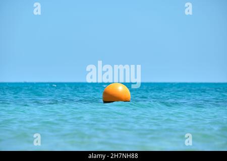 Bouée orange flottant sur les vagues de la surface de la mer.Concept de sécurité de la vie humaine. Banque D'Images