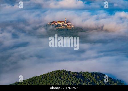 Ancienne ville de Buzet avec clocher et vieux bâtiments survolant les nuages.Paysage inhabituel de destination touristique en Istrie, Croatie Banque D'Images