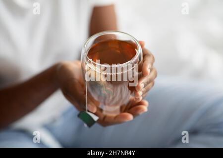 Femme noire méconnue dans des confitures tenant une tasse avec du thé Banque D'Images