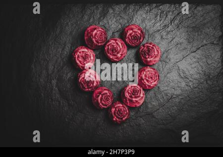 Cupcakes rouges sous forme de coeur sur fond noir.Coeur fait de cupcakes. Banque D'Images