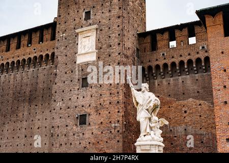 Sculpture d'un homme avec une croix près du mur du Castello Sforzesco.Milan, Italie Banque D'Images