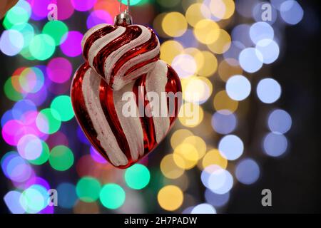 Jouets de Noël en forme de cœur sur fond de lumières floues.Décorations du nouvel an et éclairage festif Banque D'Images