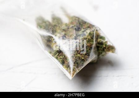 Bouton de fleur de marijuana dans un sac en plastique à fermeture éclair sur fond blanc. Banque D'Images