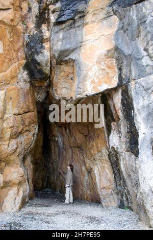 Personne visitant la grotte de Saint-Ninois, la baie de Port Castle, Dumfries & Galloway, Écosse Banque D'Images