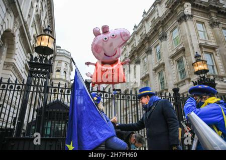 Westminster, Londres, Royaume-Uni.24 novembre 2021.Un grand ballon Peppa Pig et un jouet George Pig visitent les portes de Downing Street à Pro eu et des militants anti-gouvernementaux avec Steve Bray ont manifesté devant Downing Street, à la suite de la visite de Boris Johnson à Peppa Pig World et des commentaires ultérieurs lors du discours de la CBI.Credit: Imagetraceur/Alamy Live News Banque D'Images