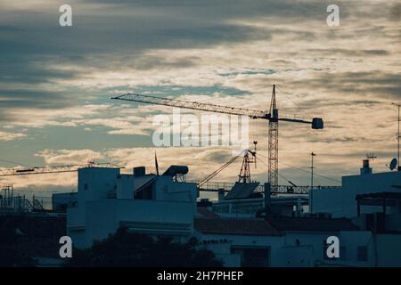 Ciel nuageux au coucher du soleil sur les bâtiments blancs de la ville Banque D'Images