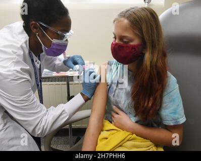 Racine, Wisconsin, États-Unis.24 novembre 2021.JORDYN CHAFFEE, 10 ans, regarde JALEESA JENKIN R.N. lui donne son coup de feu alors que la ville de racine, Wisconsin tient une clinique vaccinale COVID‚-19 pour enfants„ au département de santé de la ville mercredi 24 septembre 2021, les écoles ont été fermées pour les vacances de Thanksgiving.Le Père Noël était sur place pour donner aux enfants des canes de bonbons, des crayons et des livres de coloriage après leur inoculation.Les adultes pourraient également être inoculés.Les résidents adultes et enfants de la ville qui ont reçu leurs premiers coups ont reçu des chèques-cadeaux de 50 $.(Image de crédit : © Mark Hertzberg/ZUMA Press Wire) Banque D'Images