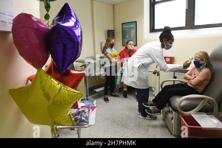 Racine, Wisconsin, États-Unis.24 novembre 2021.EMILY CHAFFEE, 8 ans, a pris sa température par JALEESA JENKIN R.N. comme la ville de racine, Wisconsin tient une clinique de vaccins COVID-19 Pfizer pour enfants au département de santé de la ville mercredi 24 septembre 2021, les écoles ont été fermées pour les vacances de Thanksgiving.Le Père Noël était sur place pour donner aux enfants des canes de bonbons, des crayons et des livres de coloriage après leur inoculation.Les adultes pourraient également être inoculés.Les résidents adultes et enfants de la ville qui ont reçu leurs premiers coups ont reçu des chèques-cadeaux de 50 $.(Image de crédit : © Mark Hertzberg/ZUMA Press Wire) Banque D'Images