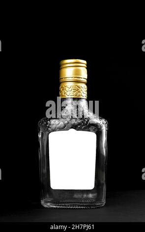 Étiquette Mockup sur une bouteille de whisky, de cognac ou de vodka en verre vide sur fond noir.Modèle, copier la photo d'espace Banque D'Images