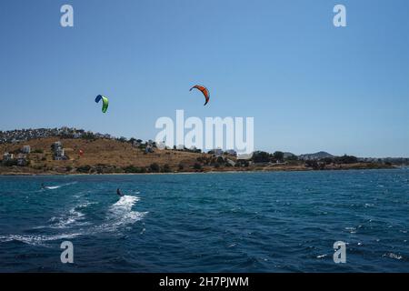 Deux hommes surfent sur cerf-volant dans la mer Méditerranée avec la toile de fond d'une péninsule avec des maisons blanches, Bodrum, Turquie.Concept de style de vie sportif.Kit Banque D'Images