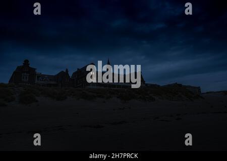 Vieille clinique effrayante dans les dunes de berck sur mer, France.Photographie de nuit effrayante, deux fenêtres sont mystérieusement illuminées. Banque D'Images