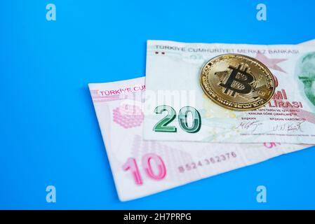 le bitcoin et la lire turque sur fond bleu. Crise de dépréciation.Les pièces de crypto-monnaie Bitcoin sur les billets de Lira turcs.Crypto-monnaie a Banque D'Images