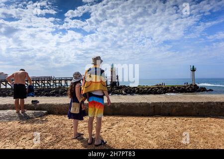 Deux baigneurs ont vue sur l'océan Atlantique à Hossegor, au sud de la France, en face des deux maisons de lumière et du quai de Capbreton. Banque D'Images