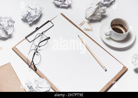 Des papiers froissés éparpillés, des tasses vides de café sur la table d'un travailleur de la création. Crise créative. Concept de stress, de troubles de santé mentale et de manque de moi Banque D'Images