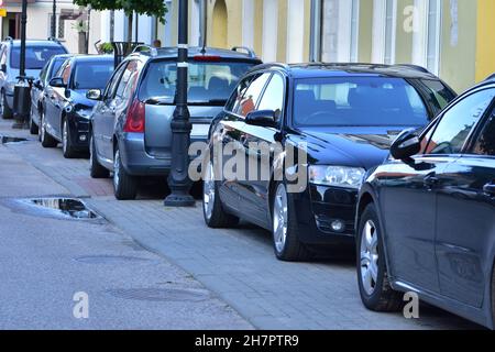 Voitures de tourisme dans un parking séparé de la voie publique à côté des maisons résidentielles. Banque D'Images