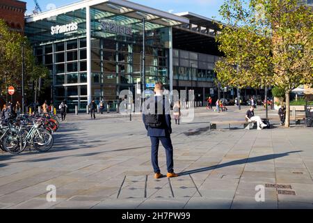 Jeune homme vue arrière portant un costume et un sac à dos à dos attendant devant la gare de St Pancras près de Kings Cross London UK KATHY DEWITT Banque D'Images