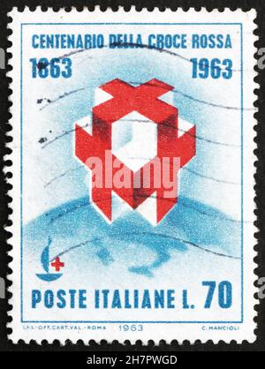 ITALIE - VERS 1963 : un timbre imprimé en Italie montre des croix et un emblème du Centenaire sur le Globe, Centenaire, de la fondation de la Croix-Rouge internationale, vers 19 Banque D'Images