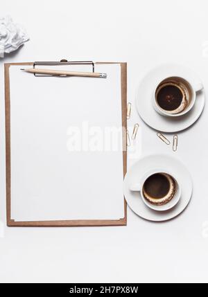 Des papiers froissés éparpillés, des tasses vides de café sur la table d'un travailleur de la création. Crise créative. Concept de stress, de troubles de santé mentale et de manque de moi Banque D'Images