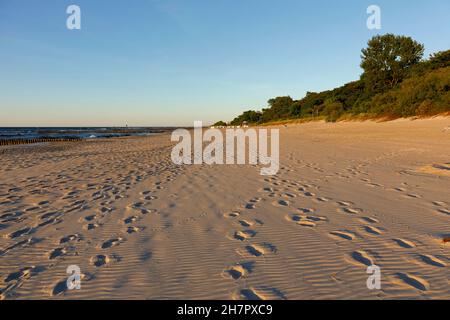 Une large et longue plage de sable sur la mer Baltique est vue juste avant le coucher du soleil à Kolobrzeg, en Pologne. Banque D'Images