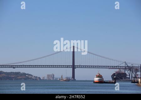 MADRID, ESPAGNE - 30 septembre 2021 : le pont suspendu du 25 avril à Lisbonne au-dessus de la belle rivière Tage avec des navires sous un ciel bleu Banque D'Images