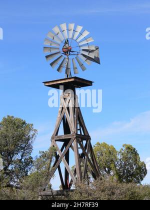 Un vieux moulin à vent pompe l'eau d'un puits dans un ranch rural de l'Arizona. Banque D'Images