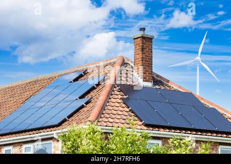 Panneaux solaires sur le toit de la maison au Royaume-Uni avec éolienne.Énergie solaire, renouvelable, verte, propre, alternative.Maison, facture d'énergie domestique... concept Banque D'Images