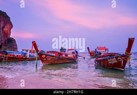 AO NANG, THAÏLANDE - 26 AVRIL 2019 : les bateaux à longue queue de bois flotent sur les vagues de marée à la plage de Phra Nang de la péninsule de Railay (Rai Leh) au coucher du soleil Banque D'Images