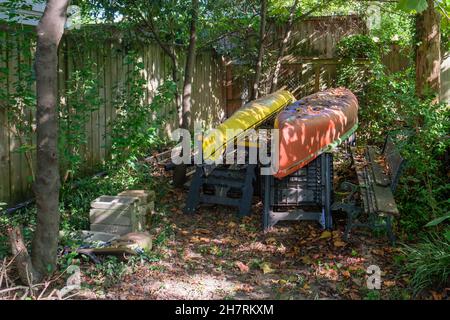 Canoë et kayak au repos dans Shaded Back Yard Banque D'Images