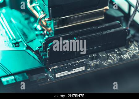 Deux bancs de mémoire sur une carte mère d'ordinateur en bleu sarcelle et lumière blanche Banque D'Images