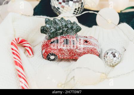 Voiture rouge avec arbre de Noël sur chandail blanc, lumières à DEL.Décoration de Noël sur la neige Banque D'Images