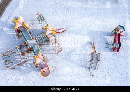 aire de jeux vide dans la cour, couverte de neige. vue aérienne sur le dessus. Banque D'Images